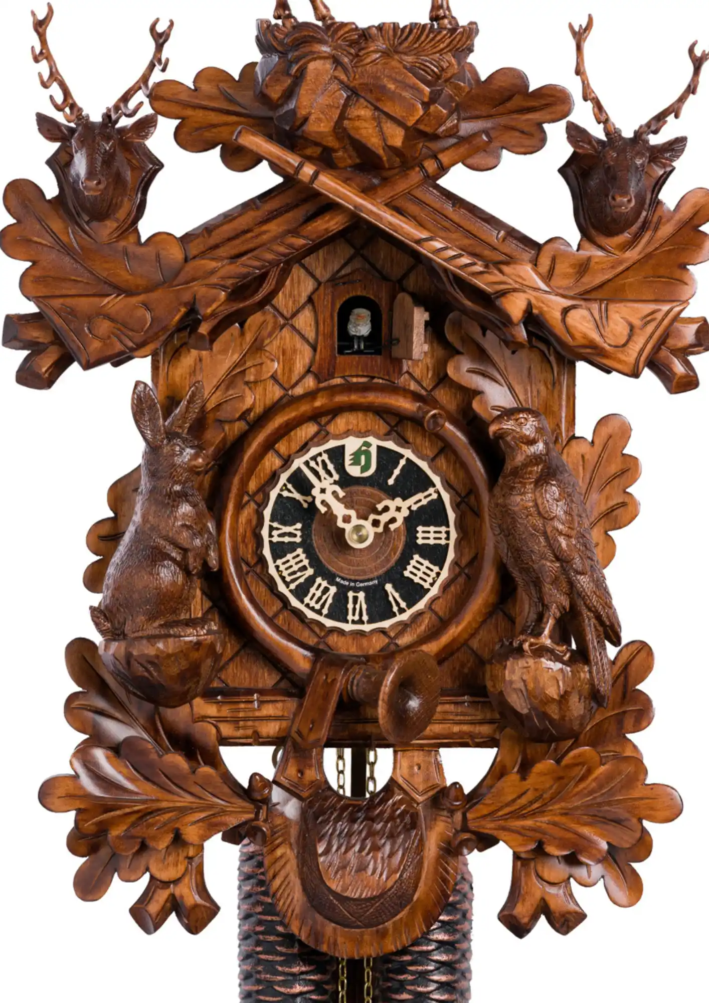 This acorn-adorned brown hunting mechanical 8 day cuckoo clock shows several animals found in the Black Forest. Precisely hand carved to the finest detail such as hunting horn wrapped around the clocks face, hounting pouch hanging beneath it, guns up the 