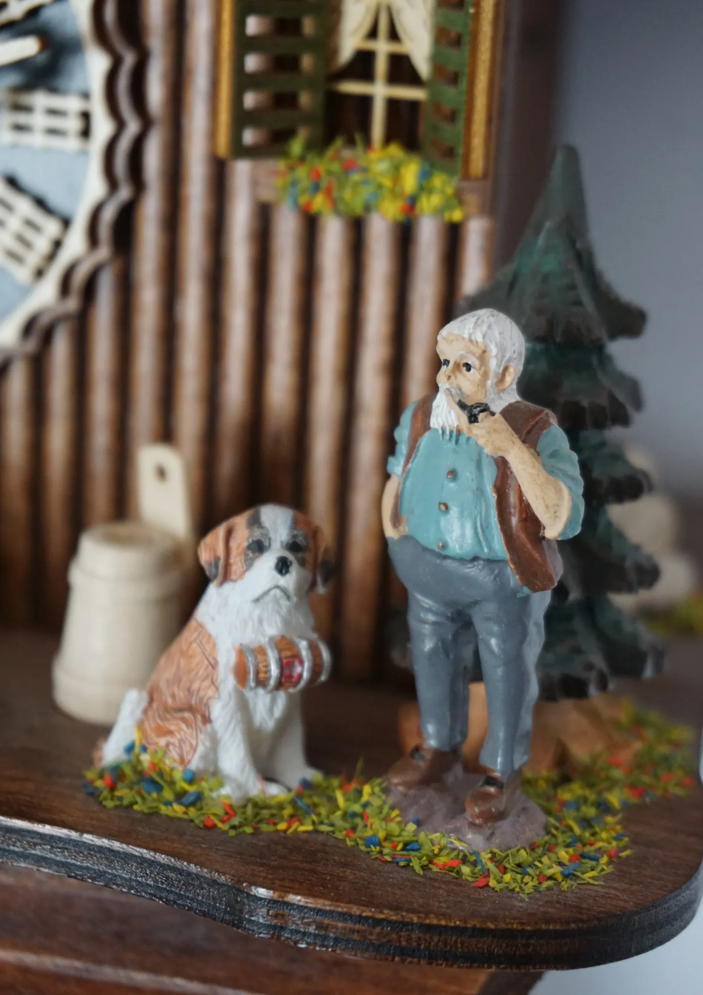 8 day mechanical black forest cuckoo clock in brown color with colorful figures from Heidi storyline, Heidi, grandpa and Peter are standing in front of the clock named Heidi House. Made by Hönes