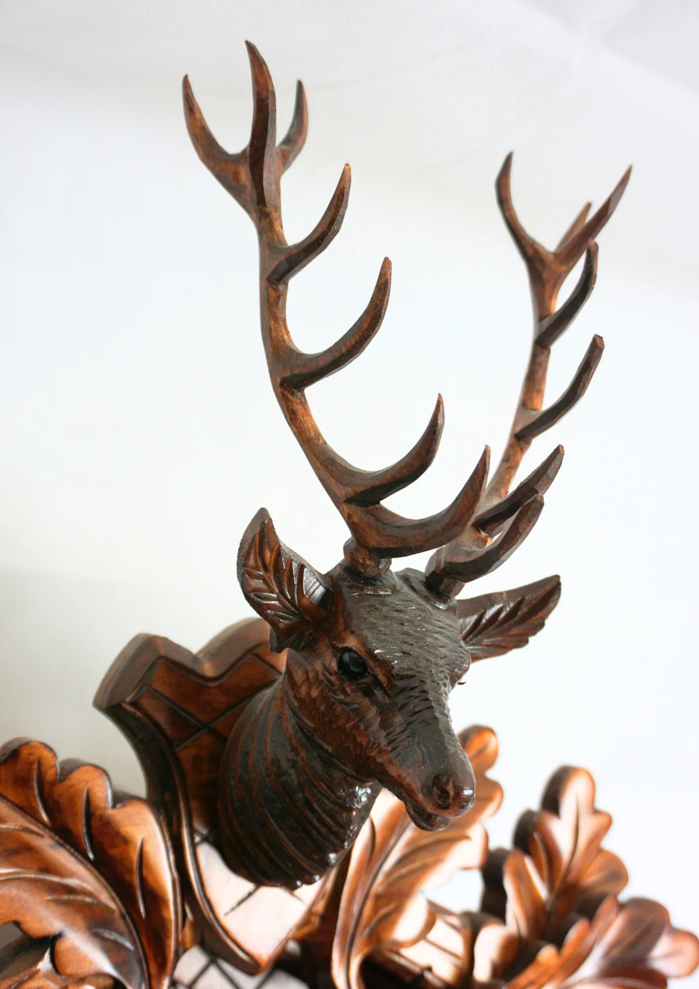 Hand carved authentic mechanical brown black forest cuckoo clock in a hunter theme. Precisely carved deer head is decorating the top while there is a hunter and a falcon figure on the sides of the clock. The clocks dial is wraped with a hunting horn while