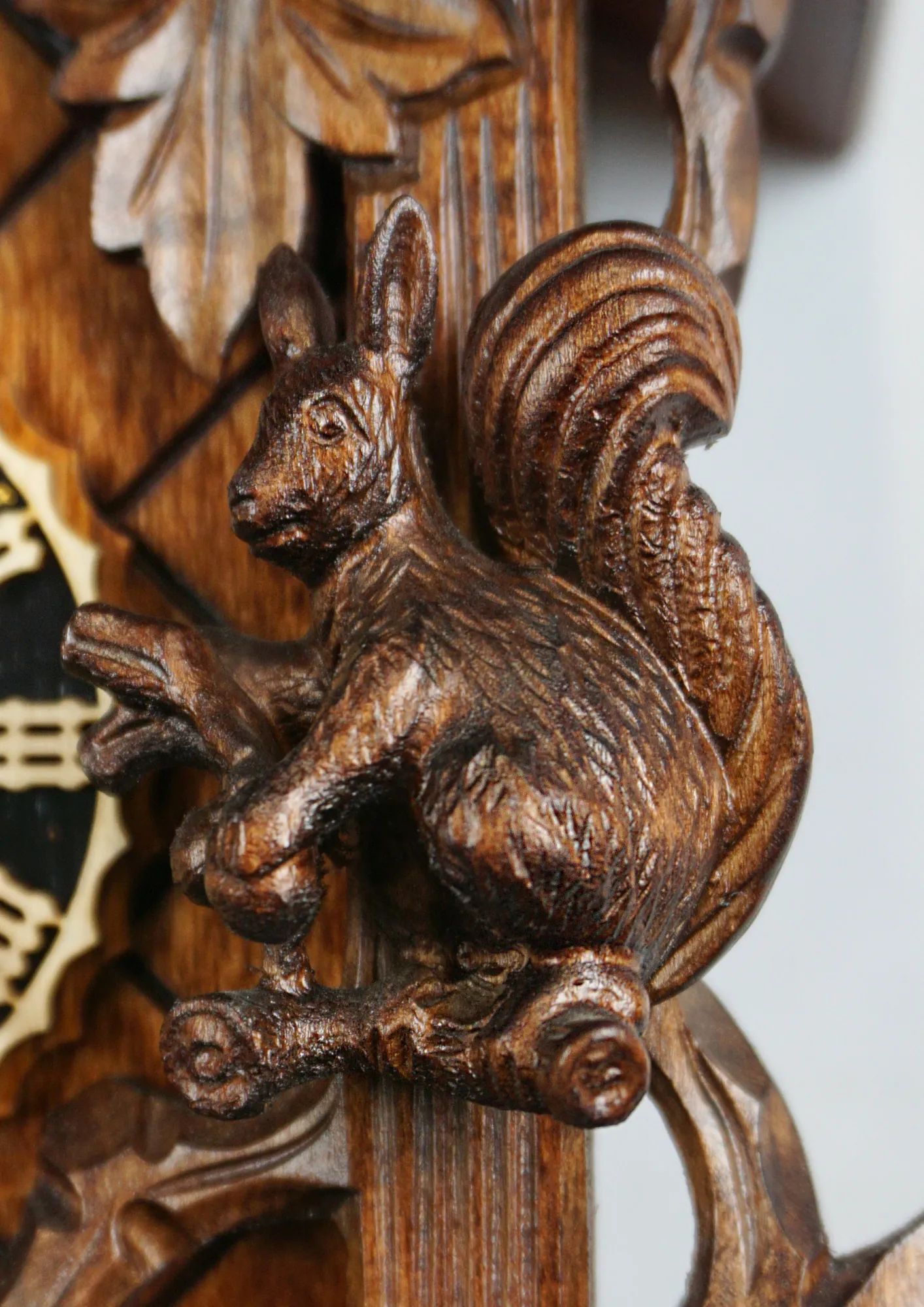 Hand carved traditional mechanical brown black forest cuckoo clock with squirrels and cuckoo bird carvings made by Hönes