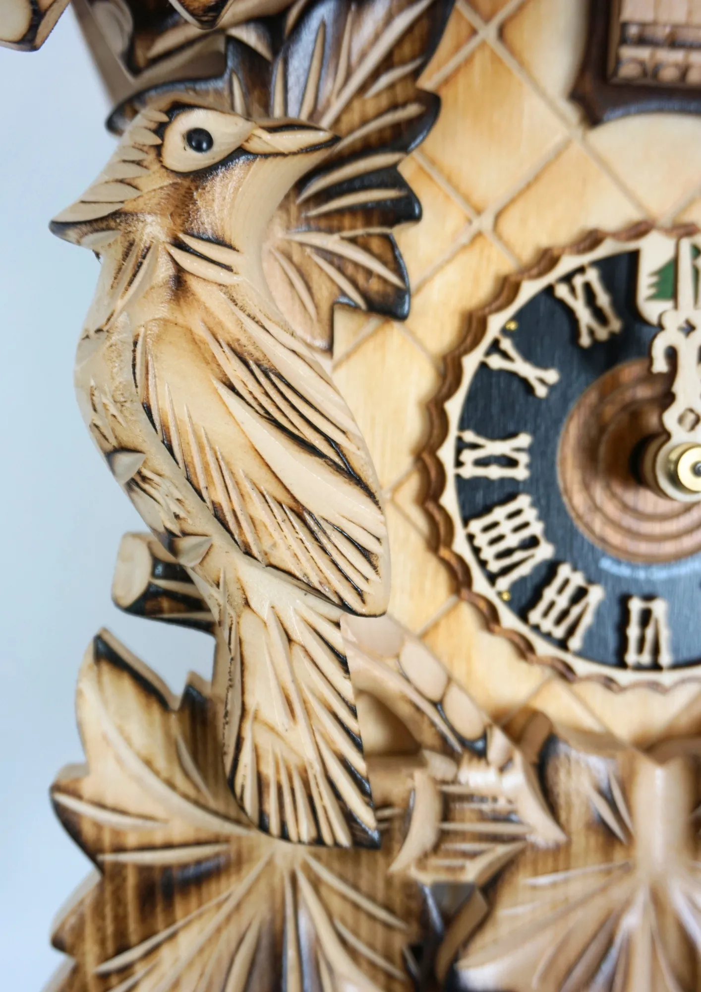 Cuckoo Clock Natural Color Wood 8 Day Movement (3) Middle sized traditional hand carved beige mechanical cuckoo clock decorated with wine leaves and with three birds with 8 days mechanism, the clock is preserved in its natural wood color, made by Hönes