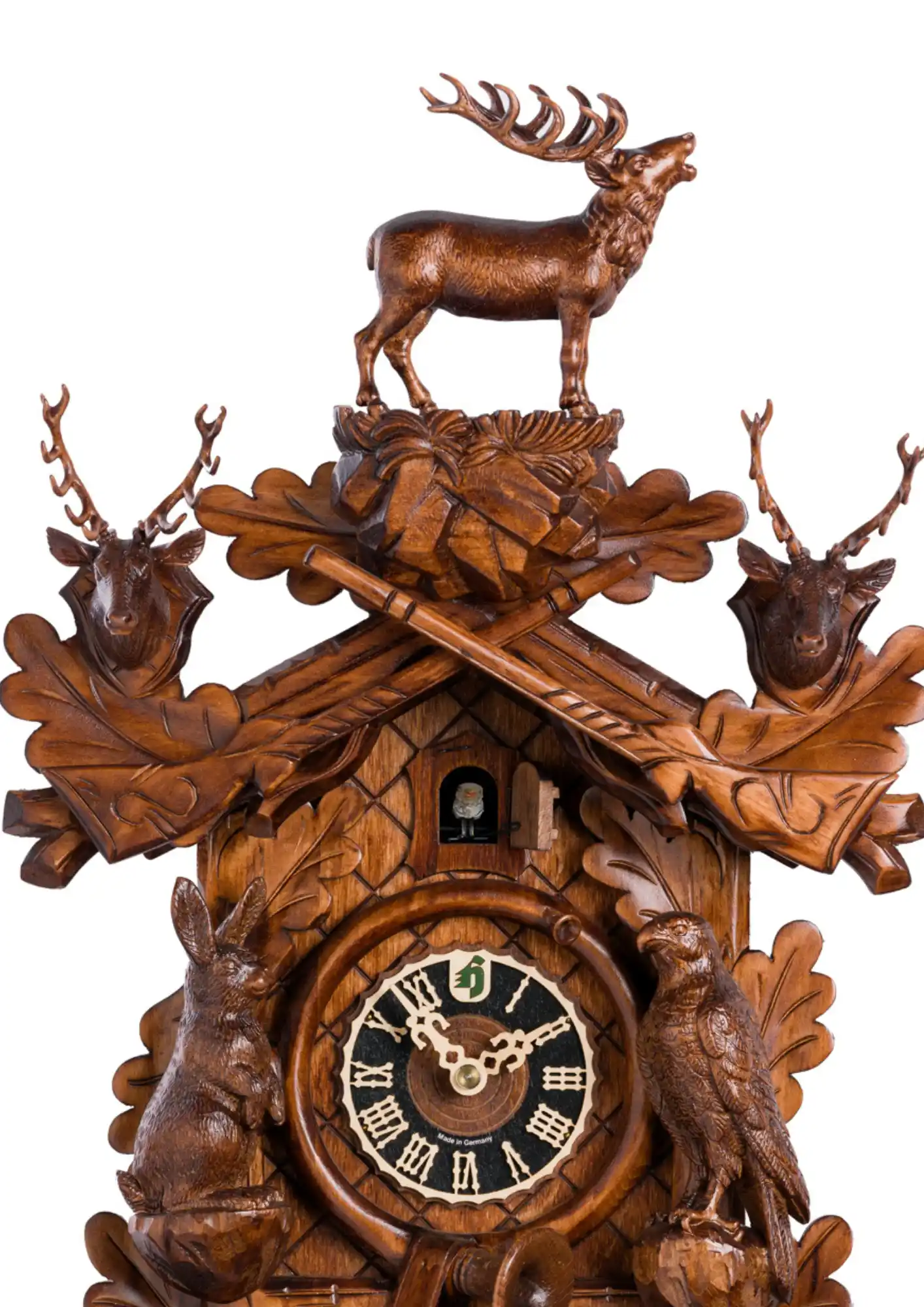 This acorn-adorned brown hunting mechanical 8 day cuckoo clock shows several animals found in the Black Forest. Precisely hand carved to the finest detail such as hunting horn wrapped around the clocks face, hounting pouch hanging beneath it, guns up the 
