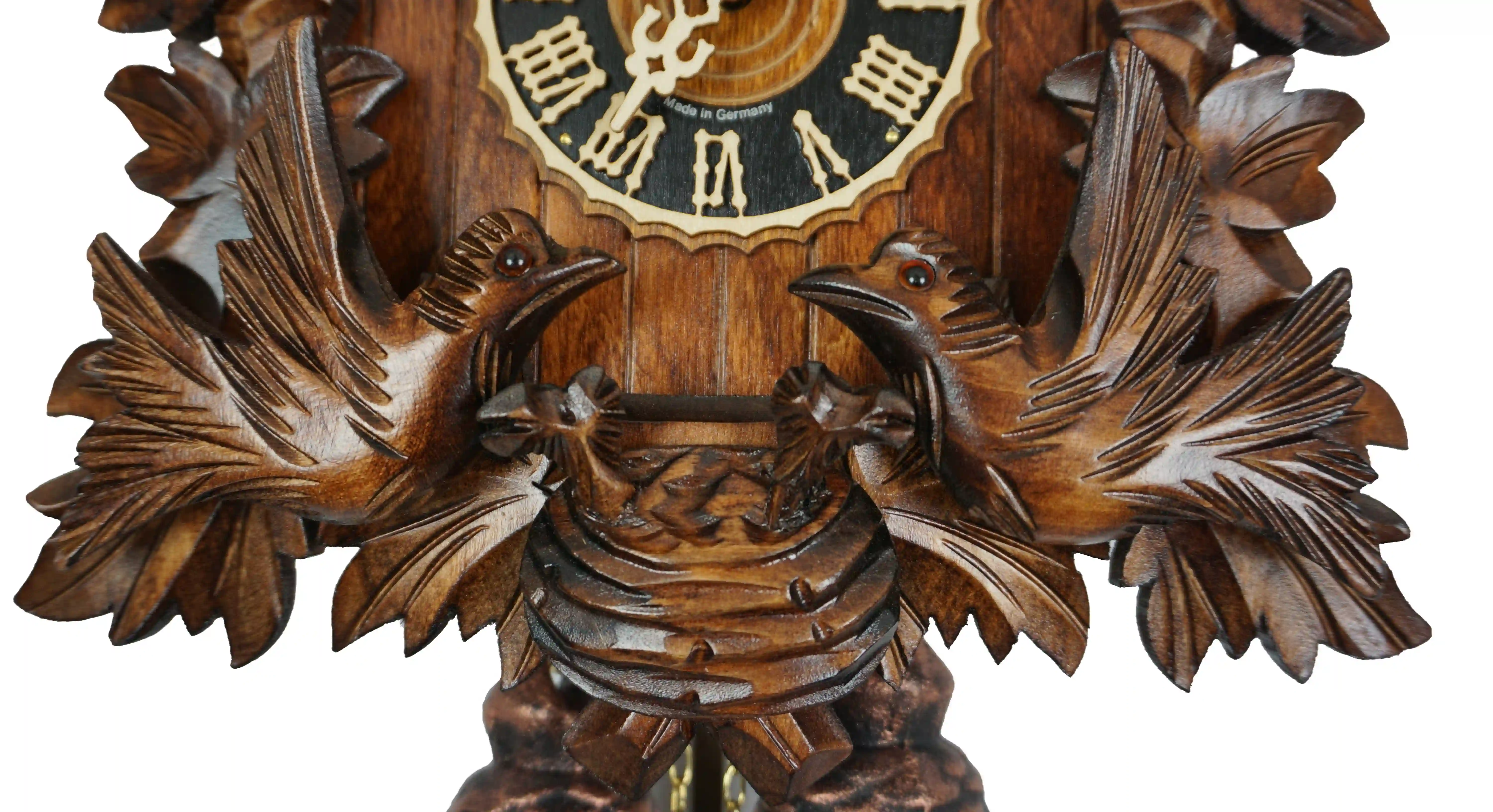 Hand carved mechanical 8 days black forest cuckoo clock with unusual design, while the frame is decorated in traditional style, the roof is covered in shingles. Two birds at the front are moving every time cuckoo comes out and feeding the offspring in the