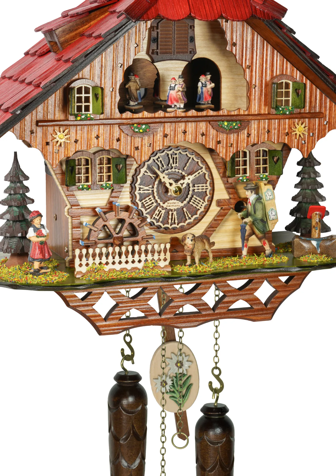 Cuckoo clock with a red roof and a clock maker with traditional Black Forest clothing moving his umbreal dancers dance while music play